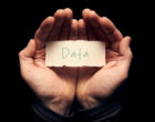 一个男人捧着一张卡片，上面手写着“数据”。