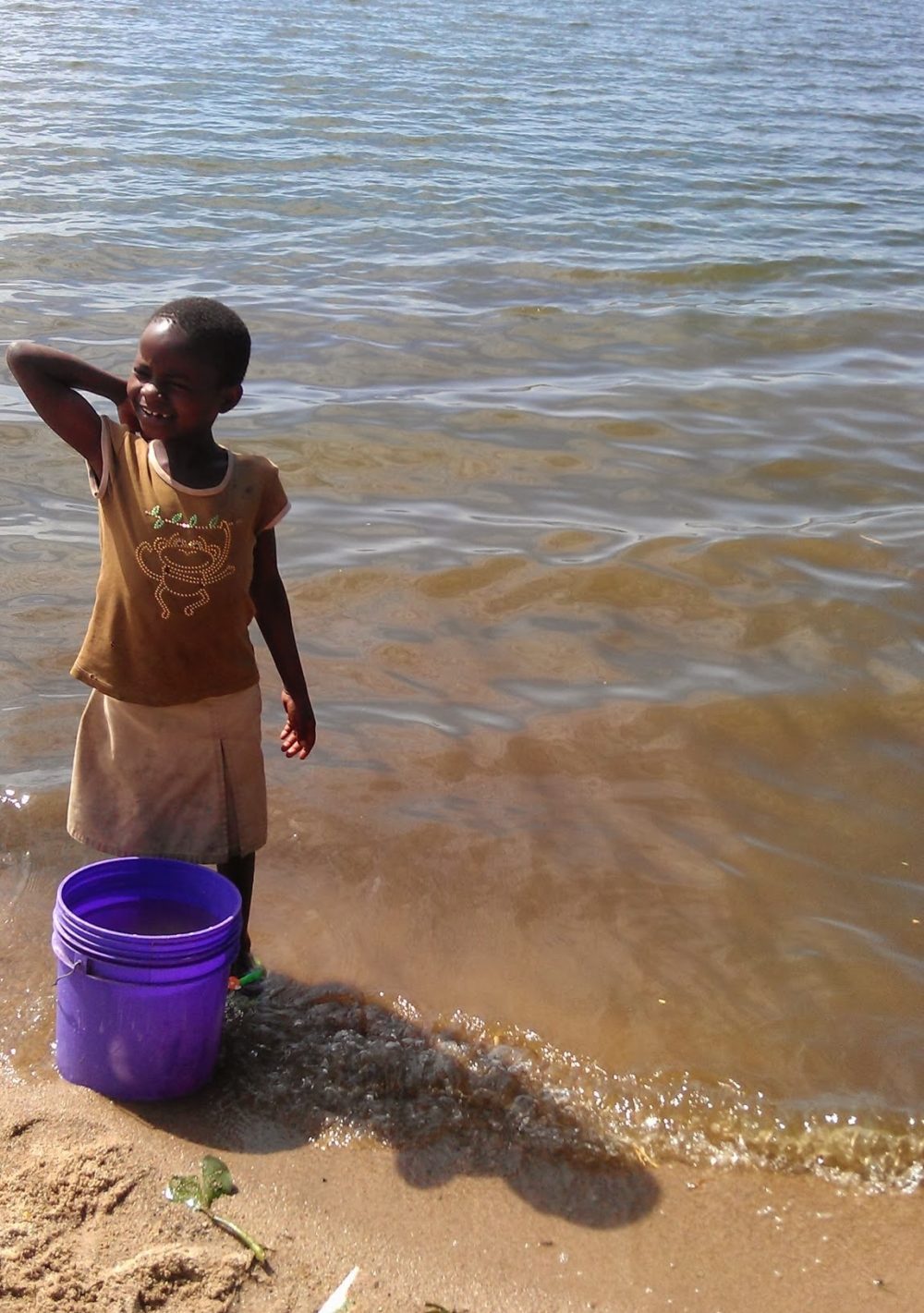 Little girl collecting water from an open water source - Access to safe water is crucial for disease prevention. Copyright Anouk Gouvras