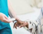 一名护士用手持设备测试病人的血糖。